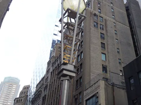 One of the Diamond District's lamp posts, topped with a glass diamond, against the brick and glass towers of West 47th Street