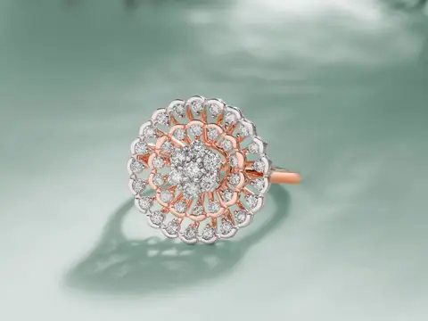 A rose and white gold cluster ring set with round diamonds on a pale green ground